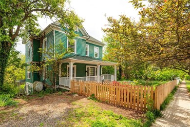 Gravel driveway and fenced front yard ready for spring plantings.