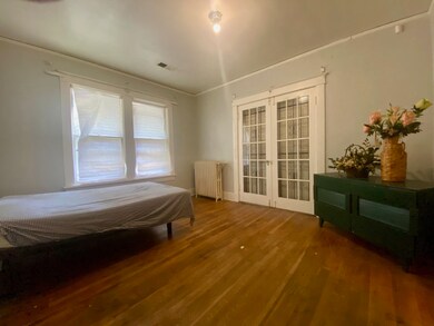 Bedroom featuring radiator, hardwood / wood-style 