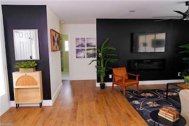 Living room featuring baseboards, ceiling fan, and