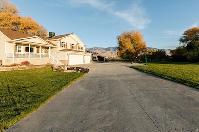 View of property exterior with a lawn, a porch, driveway, and a mountain view