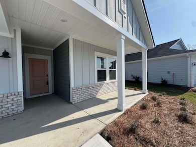 Property entrance with board and batten siding and brick siding