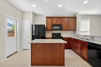 Kitchen featuring a center island, black appliances, backsplash, light tile patterned flooring, and recessed lighting