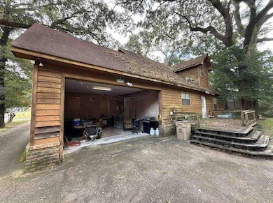 View of side of property with a deck, an attached garage, and driveway