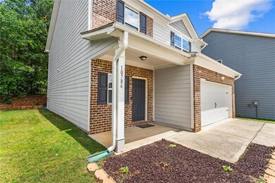 View of front of property featuring brick siding, a garage, a front lawn, and concrete driveway