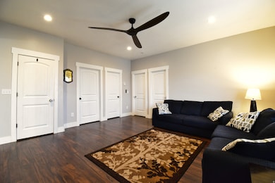 Living area featuring dark wood-style floors, recessed lighting, and ceiling fan