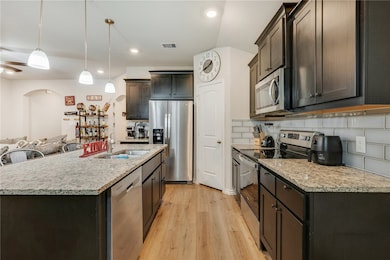 Kitchen with stainless steel appliances, a sink, l