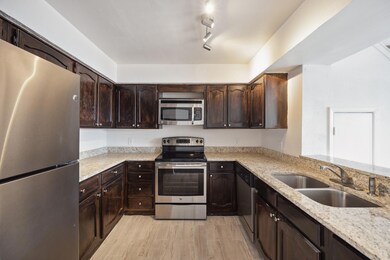 Kitchen featuring dark brown cabinetry, light hard