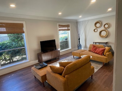 Living area with ornamental molding, wood finished floors, and recessed lighting