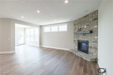 Hardwood floored living room with a textured ceiling and a fireplace