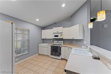 Kitchen with sink, white cabinets, light tile patt