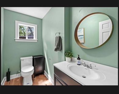 Bathroom with wood finished floors, toilet, vanit