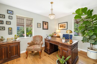 Office area with light wood-style flooring and a chandelier