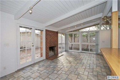 View of living room with wood burning fireplace.