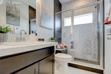 Bathroom with a shower with shower door, vanity, a