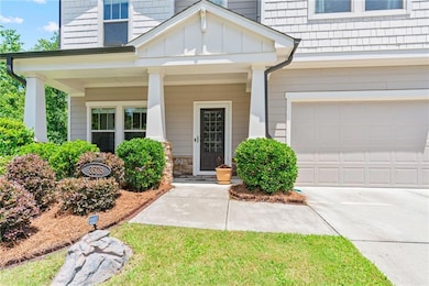 Property entrance featuring driveway, covered porch, board and batten siding, and a garage