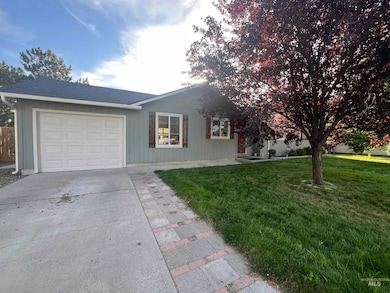 Ranch-style home with a garage, driveway, and a shingled roof