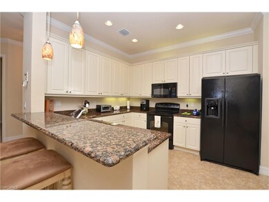 Gourmet kitchen with raised panel cabinets, cabinet lighting, granite counters and decorative pendant lights