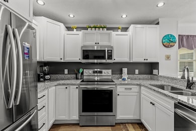Kitchen with stainless steel appliances, sink, lig