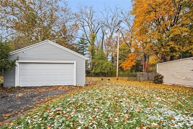 Detached garage featuring view of wooded area