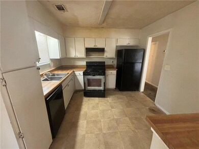 Kitchen featuring visible vents, white cabinets, a