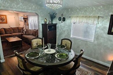 Dining space featuring dark wood-style flooring, arched walkways, and a chandelier