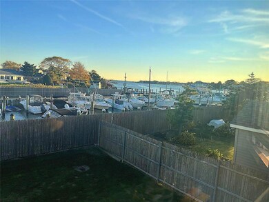 Yard at dusk featuring a water view, a fenced backyard, and a dock