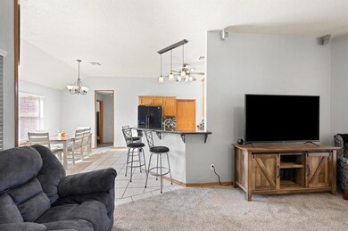 Living room with ceiling fan with notable chandeli