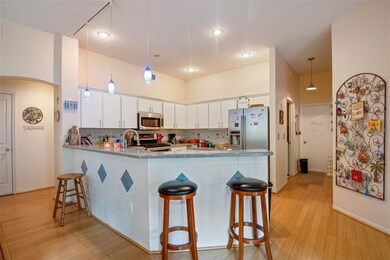 The kitchen features pendant lighting over the bre