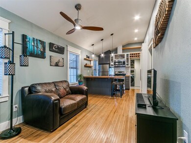 Living room with ceiling fan, vaulted ceiling, and