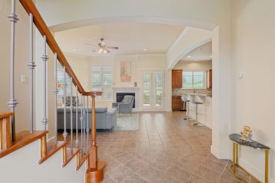 Living room featuring stairway, ceiling fan, arch