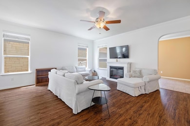 Living room featuring ceiling fan, plenty of natu