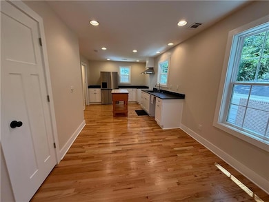 Enter into the breakfast area and see the brand new kitchen and appliances. Sunlight streams through the windows.  A coat closet is handy to the front door.