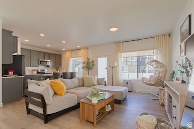 Living room with light wood-style floors and recessed lighting