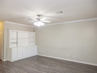 Empty room with a ceiling fan, dark wood finished