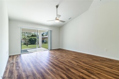 Empty room with dark wood-style floors, baseboards