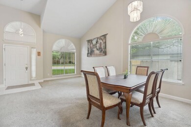 Dining room featuring light carpet, a chandelier,