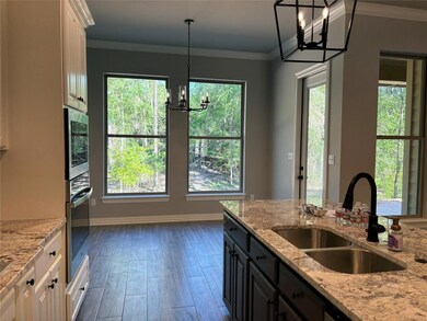 Kitchen with white cabinetry, a chandelier, stainl