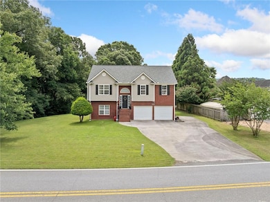 Raised ranch featuring brick siding, driveway, and a garage