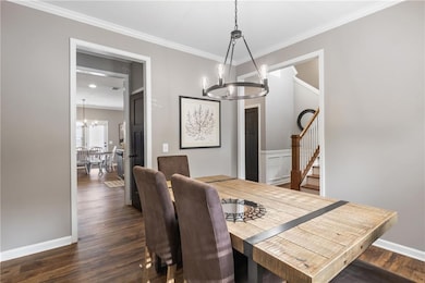 Dining area with crown molding, baseboards, dark w