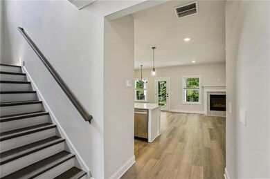 Stairs with wood finished floors, recessed lighting, and a high end fireplace