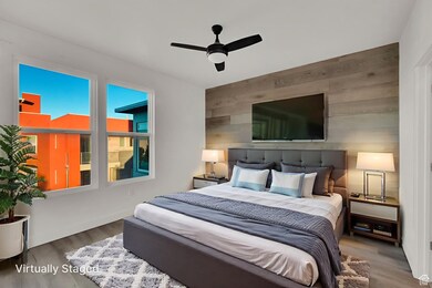 Bedroom featuring wooden walls, wood finished floors, and ceiling fan