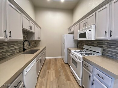 Kitchen featuring white appliances, a sink, tastef