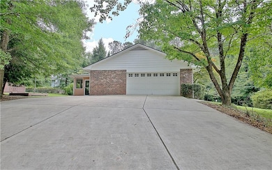 View of side of property with brick siding, concrete driveway, and a garage