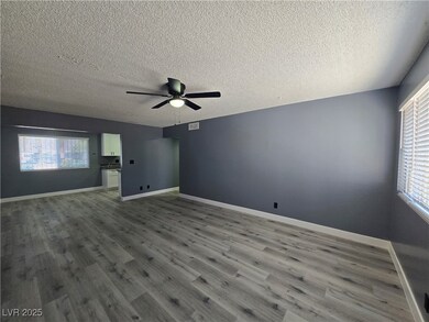 Unfurnished room featuring baseboards, a textured