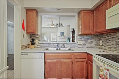 Kitchen with a textured ceiling, white appliances,