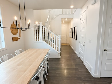 Dining space featuring dark wood-style flooring, a chandelier, stairway, and recessed lighting
