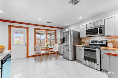 Kitchen with gray cabinets, appliances with stainl
