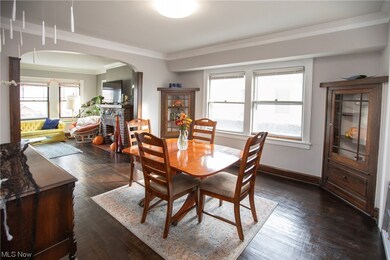 Dining room with a fireplace, crown molding, and dark hardwood / wood-style floors