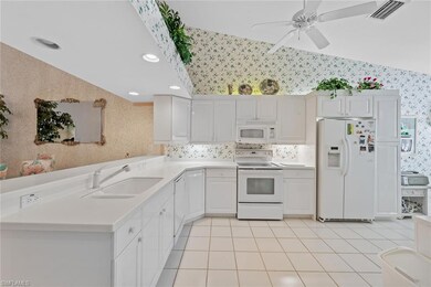 Kitchen featuring lofted ceiling, white appliances