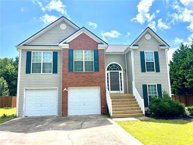 Bi-level home with asphalt driveway, a garage, and brick siding